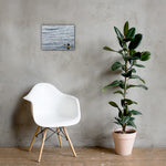 a chair and a plant in a vase on a table 